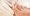 Closeup image of podologist checking the left foot toe nail suffering from fungus infection. horizontal studio picture on white background.